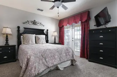 a bedroom with a bed and a flat screen tv at 5 Star Mansion with Private Pool on Formosa Gardens Orlando Manion 5075 in Orlando