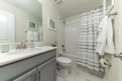 a bathroom with a sink and a toilet and a shower at The Ultimate Mansion with Private Pool on Storey Lake Resort Orlando Mansion 5287 in Kissimmee