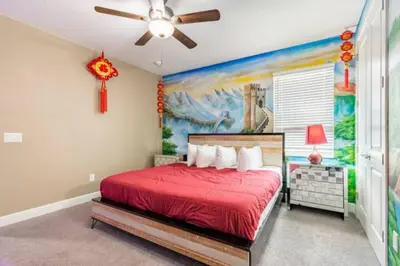 a bedroom with a red bed and a painting on the wall at Exclusive Mansion with Large Private Pool on Veranda Palms Orlando Mansion 5378 in Kissimmee