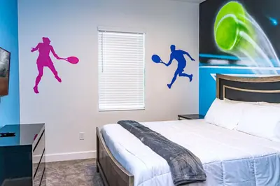 a bedroom with a bed with two jumping people on the wall at Perfect Mansion on Veranda Palms Orlando Mansion 5379 in Kissimmee