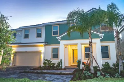 a house with a garage and a palm tree at Perfect Mansion on Veranda Palms Orlando Mansion 5379 in Kissimmee