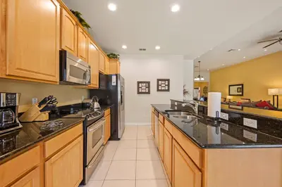 a large kitchen with wooden cabinets and black counter tops at Luxury Villa with Pool on Windsor Hills Resort Orlando Villa 5390 in Orlando