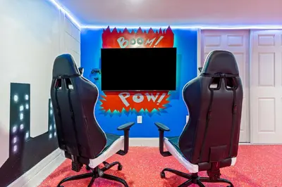 two chairs in front of a room with a tv at Beautiful Mansion with first class amenities on Solara Resort Orlando Mansion 5715 in Orlando