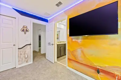 a large flat screen tv on a wall in a room at Beautiful Mansion with first class amenities on Solara Resort Orlando Mansion 5715 in Orlando