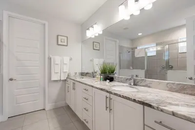 a bathroom with two sinks and a large mirror at Rent the Perfect 5 Bedroom Villa Encore Resort Villa 6416 in Orlando