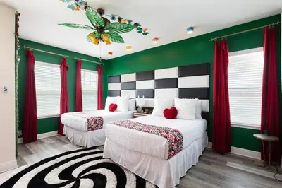 two beds in a room with green walls and red curtains at Unleash Your Dreams in a Magical Getaway in Orlando