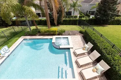 a swimming pool with two lounge chairs and a swimming pool at Unleash Your Dreams in a Magical Getaway in Orlando