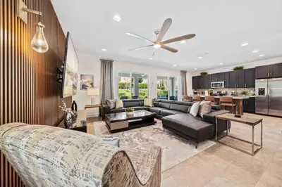 a living room with a couch and a ceiling fan at Experience Magic and Luxury Just Minutes from Disney in Orlando