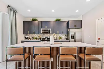 a kitchen with a large island with bar stools at Experience Magic and Luxury Just Minutes from Disney in Orlando