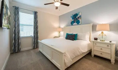 a bedroom with a white bed and a ceiling fan at Dive into Luxury and Fun at Your Orlando Paradise in Orlando