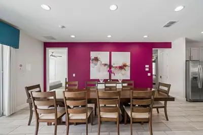 a dining room with a purple wall and a table and chairs at Indulge in Opulence: Where Comfort Meets Endless Fun in Orlando