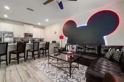 a living room with a couch and a table at Outdoor Movie Theatre! Heated Private Pool! 4 Mi to Disney! Grill in Kissimmee