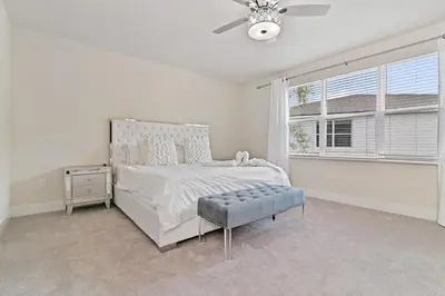 a white bedroom with a bed and a window at New Luxury Dream Vacation Home With Gym, 70 inch TV, Private Pool, 4 Bedrooms, 3 Full Baths, High Speed WiFi in Orlando