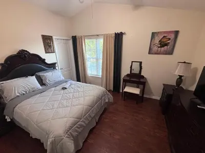 a bedroom with a bed and a table and a window at Luxury Apartment with Lake view in Orlando