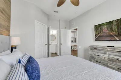 a white bedroom with a bed and a ceiling fan at The Perch-2 Miles from Disney, Movie Theatre & Water Park in Orlando