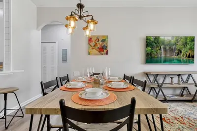 a dining room with a wooden table and chairs at The Perch-2 Miles from Disney, Movie Theatre & Water Park in Orlando