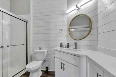 a white bathroom with a toilet and a mirror at The Perch-2 Miles from Disney, Movie Theatre & Water Park in Orlando
