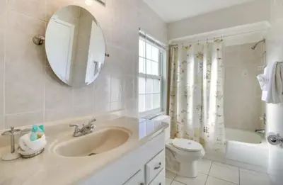 a bathroom with a sink and a toilet and a mirror at Florida Gem in Kissimmee