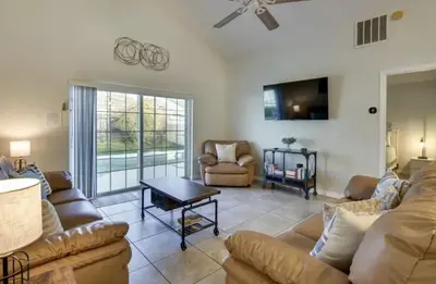a living room with a couch and a tv at Florida Gem in Kissimmee