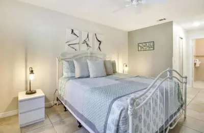 a bedroom with a white bed with a blue comforter at Florida Gem in Kissimmee