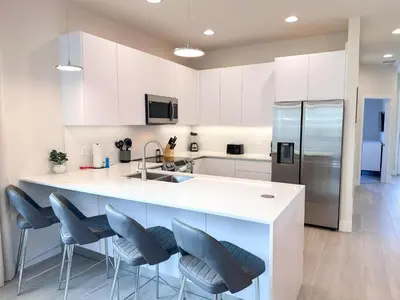 a kitchen with white cabinets and blue chairs at TR1421SL - Brand new Mykonos property in Orlando