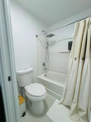 a white bathroom with a toilet and a shower at Family stay Near Disney in Kissimmee