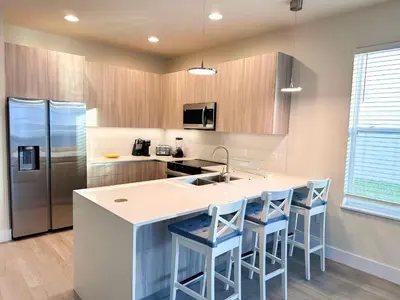 a kitchen with a large island with blue bar stools at TR1399 – 4BR - 8 guests in Orlando