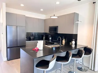 a kitchen with a counter with chairs and a refrigerator at TR1391 – 4 Bedrooms Home with pool near Disney in Clermont