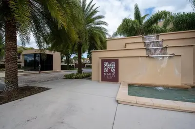 a fountain in front of a building with palm trees at Disney Escape Modern 3BR Townhouse 2 Miles to the Parks 4 Baths in Orlando
