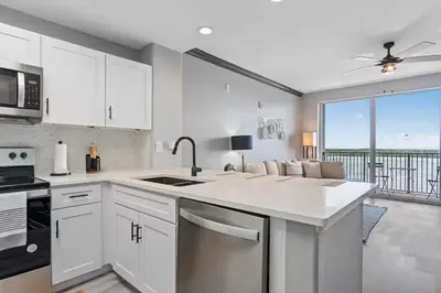 a kitchen with white cabinets and a view of the ocean at LUXURY 1br LAKEVIEW CONDO NEAR DISNEY! in Orlando