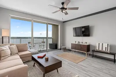 a living room with a couch and a flat screen tv at LUXURY 1br LAKEVIEW CONDO NEAR DISNEY! in Orlando