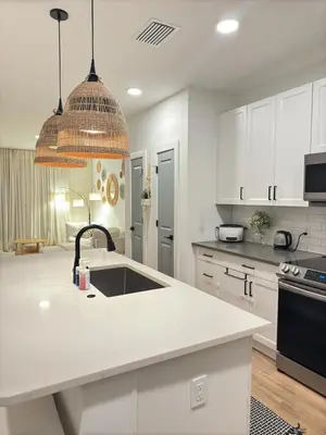 a kitchen with white cabinets and a sink at Modern 1 bedroom Apartment and Den in Orlando in Orlando