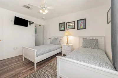 a bedroom with two beds and a tv at Family Home w/ Pool & Water Views, Near Disney in Kissimmee