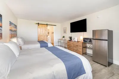a bedroom with two beds and a flat screen tv at Charming Suite: Smart TV, Modern Amenities & Pool Access in Kissimmee
