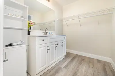 a white bathroom with a sink and a shower at Charming Suite: Smart TV, Modern Amenities & Pool Access in Kissimmee