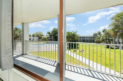 a balcony with a view of a park at Charming Suite: Smart TV, Modern Amenities & Pool Access in Kissimmee