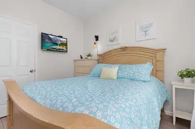 a bedroom with a wooden bed with a blue blanket at Windsor Hills Home with Pool & Near Disney in Orlando