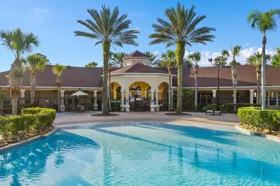 a swimming pool in front of a building with palm trees at Windsor Hills Home with Pool & Near Disney in Orlando