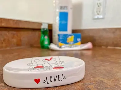 a white plate with the word love on it on a counter at Oakwater Resort Home w/ Arcade & Pool Table - 15 Min to Disney in Orlando