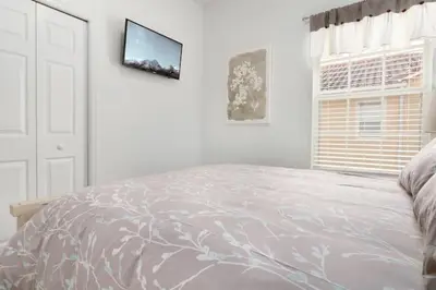 a white bedroom with a bed and a window at Oakwater Resort Home w/ Arcade & Pool Table - 15 Min to Disney in Orlando