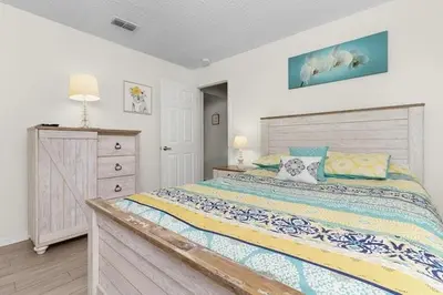 a bedroom with a large bed and a dresser at Indian Ridge Home w/ Private Pool & Game Room near Disney in Orlando
