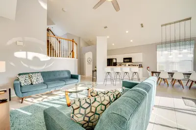 a living room with two blue couches and a kitchen at 3 Mi to Disney Family-Friendly Home! in Orlando