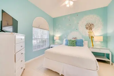 a bedroom with a white bed and blue walls at 3 Mi to Disney Family-Friendly Home! in Orlando