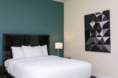 a bedroom with a white bed and a painting on the wall at 421 NP - Exquisite Retreat at Encore Resort in Orlando
