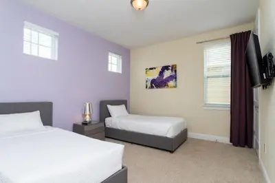 a bedroom with two beds and a flat screen tv at 421 NP - Exquisite Retreat at Encore Resort in Orlando