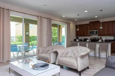 a living room with two chairs and a table and a kitchen at 421 NP - Exquisite Retreat at Encore Resort in Orlando