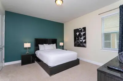 a bedroom with a white bed and a blue wall at 421 NP - Exquisite Retreat at Encore Resort in Orlando
