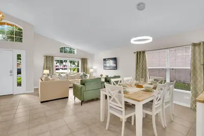 a dining room and living room with a table and chairs at Stunning Emerald Island Resort Vacation Home with Pool Spa and Access to Clubhouse in Kissimmee