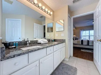 a large bathroom with two sinks and a bed at Emerald Island Four Bed Pool Home close to Disney villa in Kissimmee