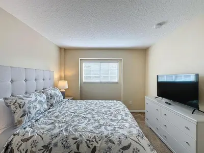 a bedroom with a bed and a flat screen tv at Emerald Island Four Bed Pool Home close to Disney villa in Kissimmee